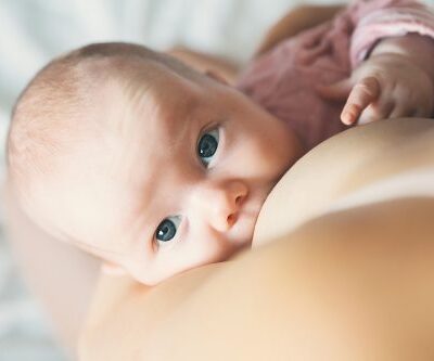 newborn baby breastfeeding and looking up at the camera
